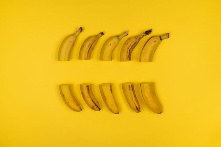 Creative composition of sliced bananas arranged on a vivid yellow surface.